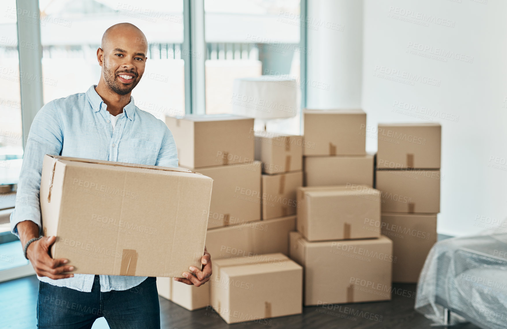 Buy stock photo Portrait of a young man carrying a box while moving house