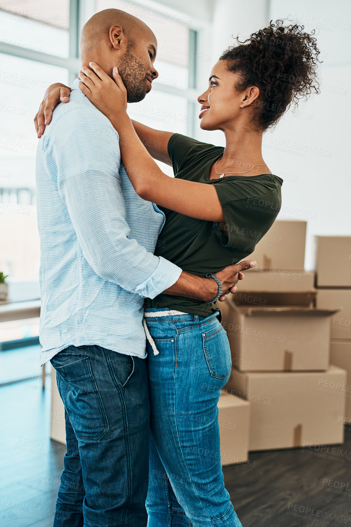 Buy stock photo Couple, smile and hug in new home with boxes, connection and excited for fresh start with property. African man, woman and moving with package in apartment, real estate and investment with mortgage