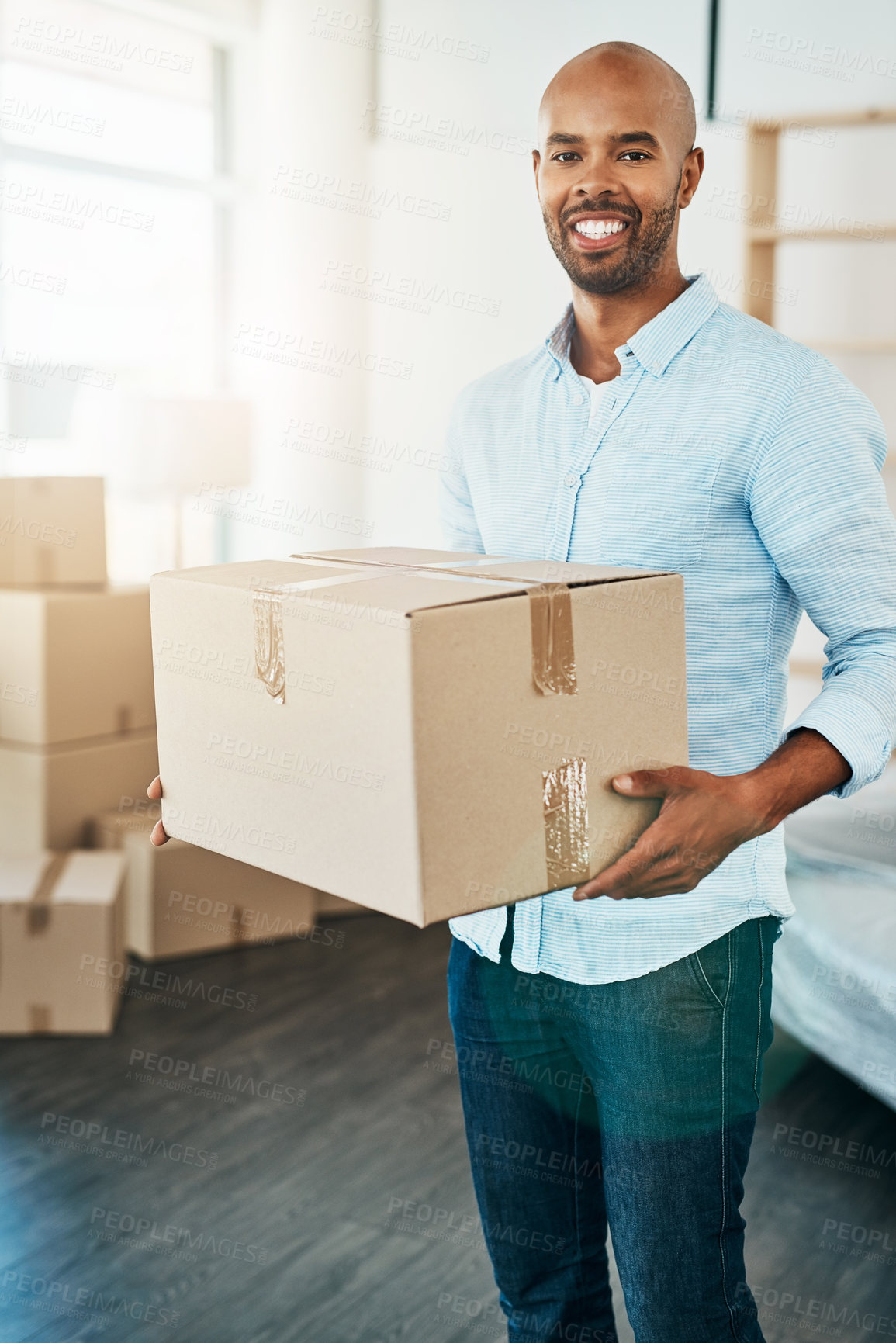Buy stock photo Portrait of a young man carrying a box while moving house