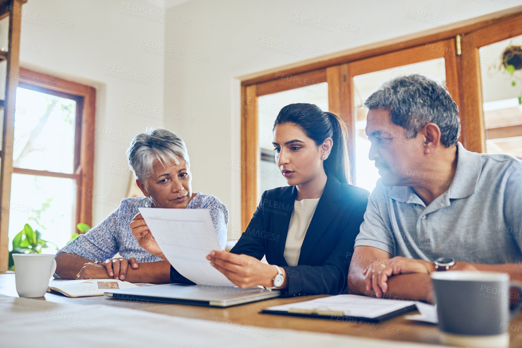 Buy stock photo Shot of a mature couple getting advice from their financial consultant at home