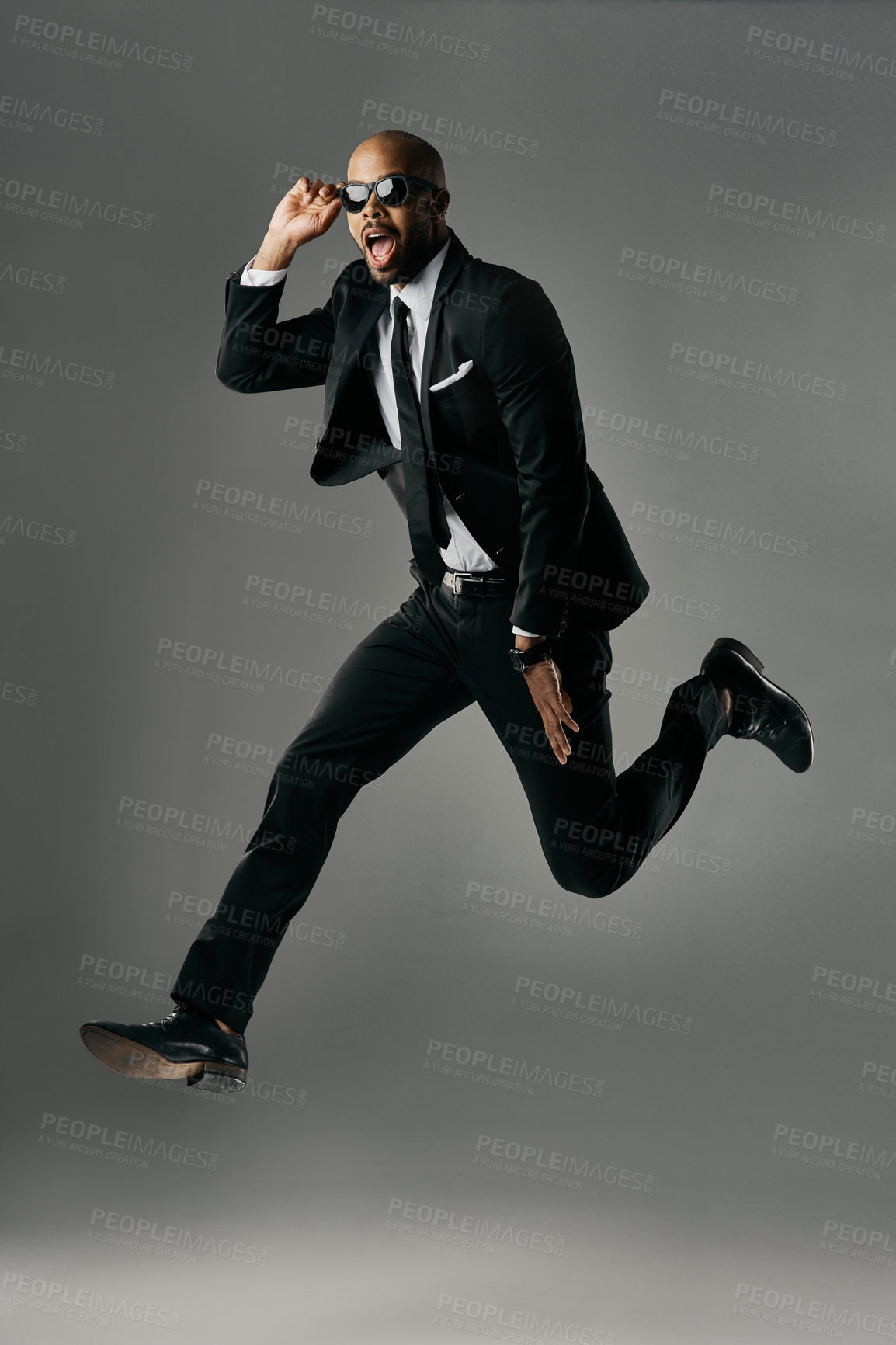 Buy stock photo Black businessman, excited or jumping for success in studio, sunglasses or suit for triumph. Job promotion, confident or corporate victory celebration with happy energy for winning by gray background