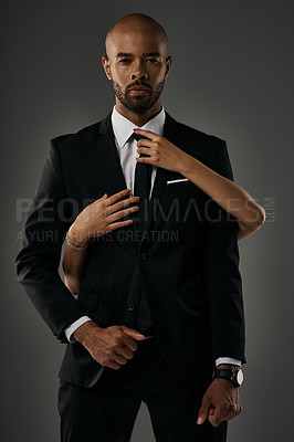 Buy stock photo Studio portrait of a handsome young businessman being touched by an unrecognizable woman against a gray background