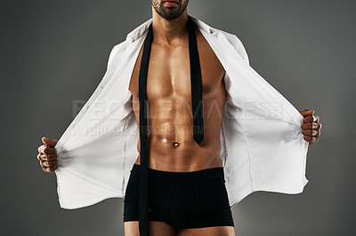 Buy stock photo Studio shot of a sexy unrecognizable man showing off his abs against a gray background