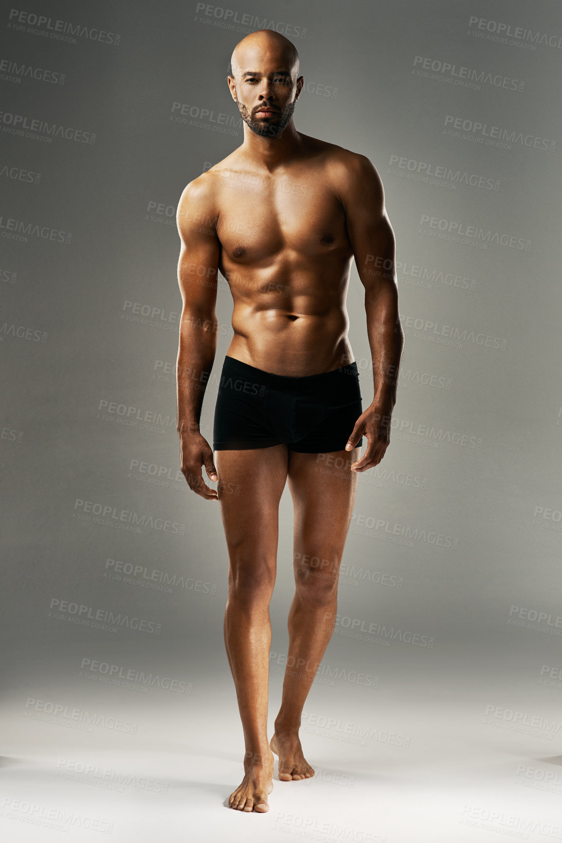 Buy stock photo Studio portrait of a sexy young man against a gray background in his underwear