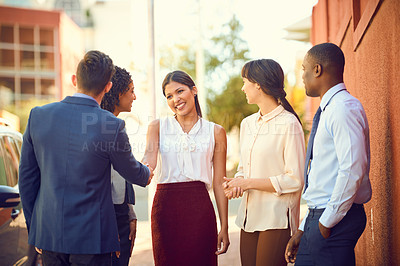 Buy stock photo Shot of businesspeople shaking hands while out in the city