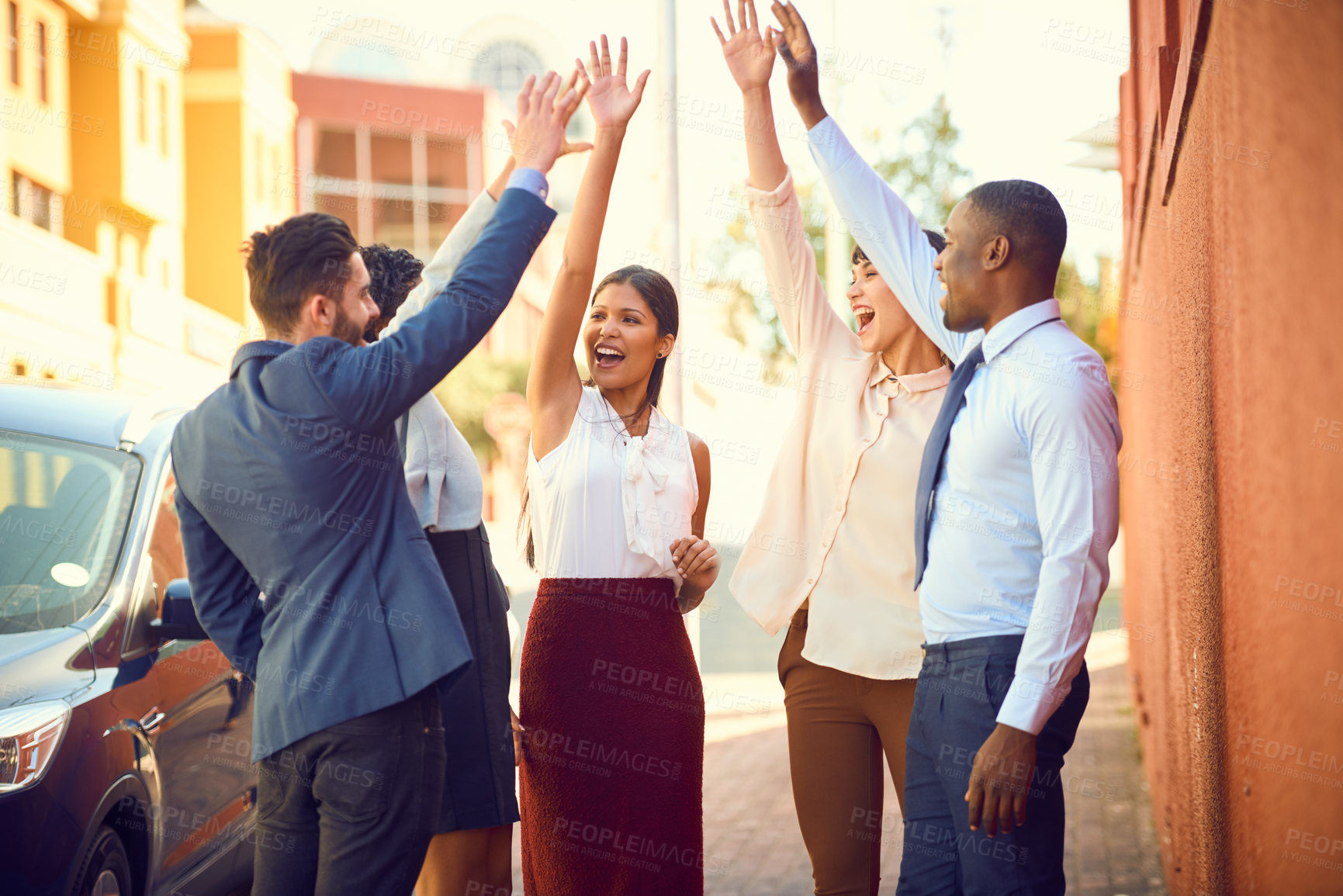 Buy stock photo Shot of a group of businesspeople high fiving together outdoors