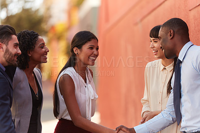 Buy stock photo Shot of businesspeople shaking hands while out in the city