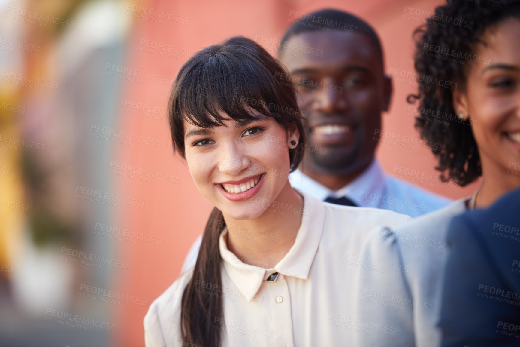 Buy stock photo Portrait of a young businesswoman standing amongst her colleagues outdoors