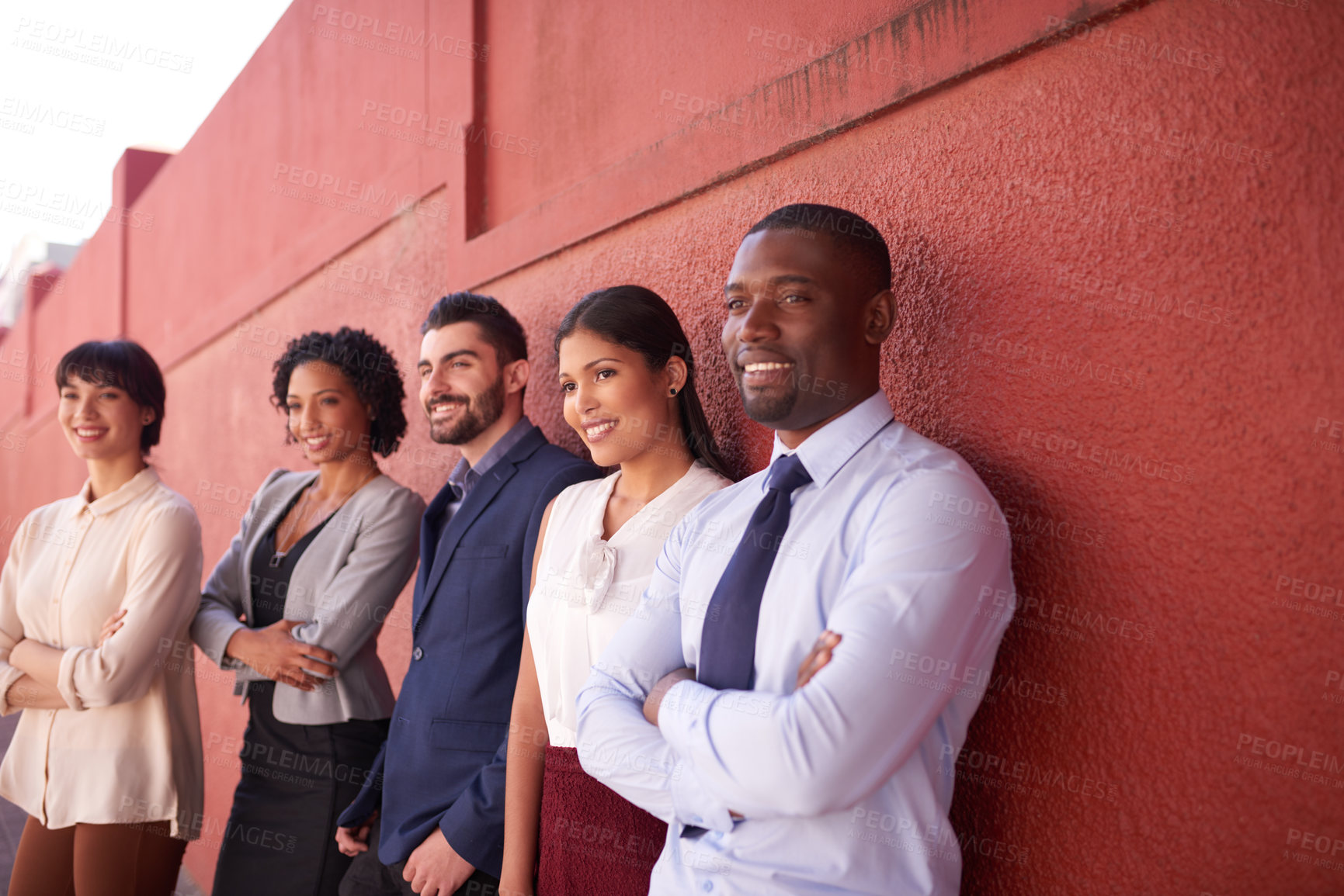 Buy stock photo Shot of a group of businesspeople standing against a red wall outdoors