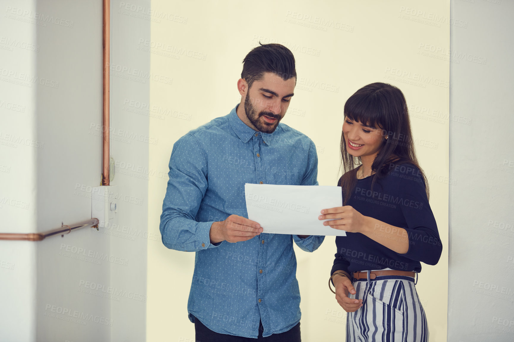 Buy stock photo Shot of a young businessman and businesswoman discussing paperwork in a modern office