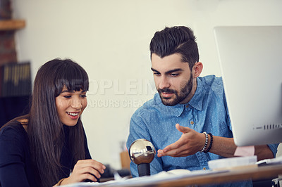 Buy stock photo Shot of a young businessman and businesswoman working together on a new design in a modern office
