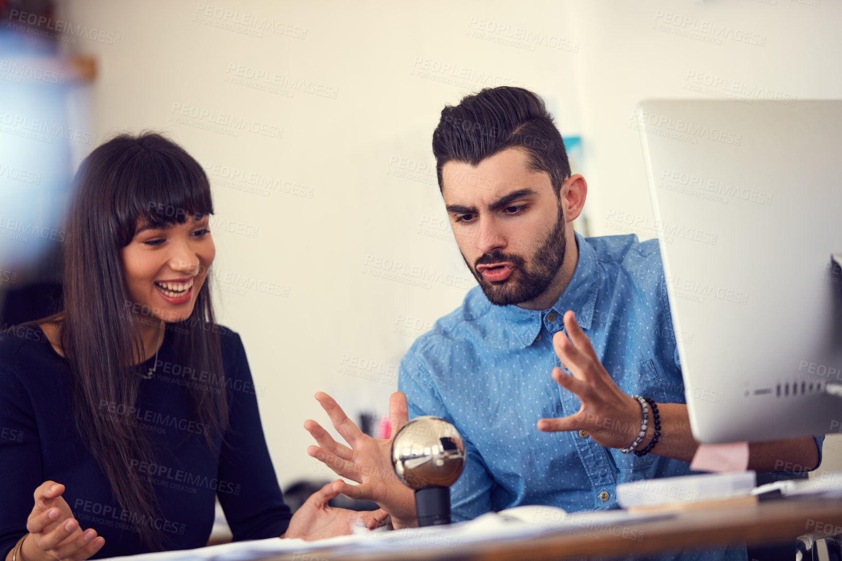 Buy stock photo Shot of a young businessman and businesswoman working together on a new design in a modern office