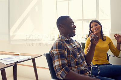Buy stock photo Shot of a young businessman and businesswoman having a discussion in a modern office