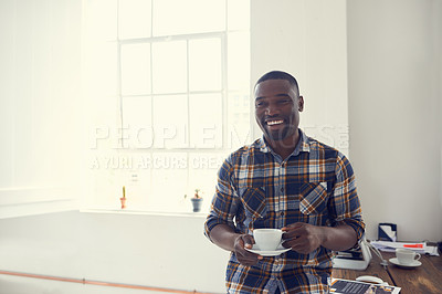 Buy stock photo Shot of a young businessman enjoying a coffee break in a modern office