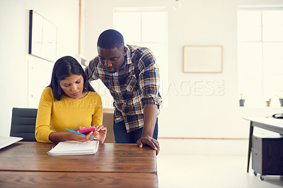 Buy stock photo Shot of a young businessman and businesswoman using a mobile phone together in a modern office