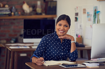 Buy stock photo Portrait of a young businesswoman writing notes at her desk in a modern office