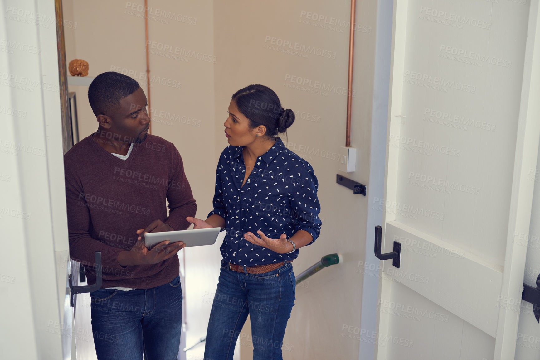 Buy stock photo Shot of a young businessman and businesswoman using a digital tablet together in a modern office