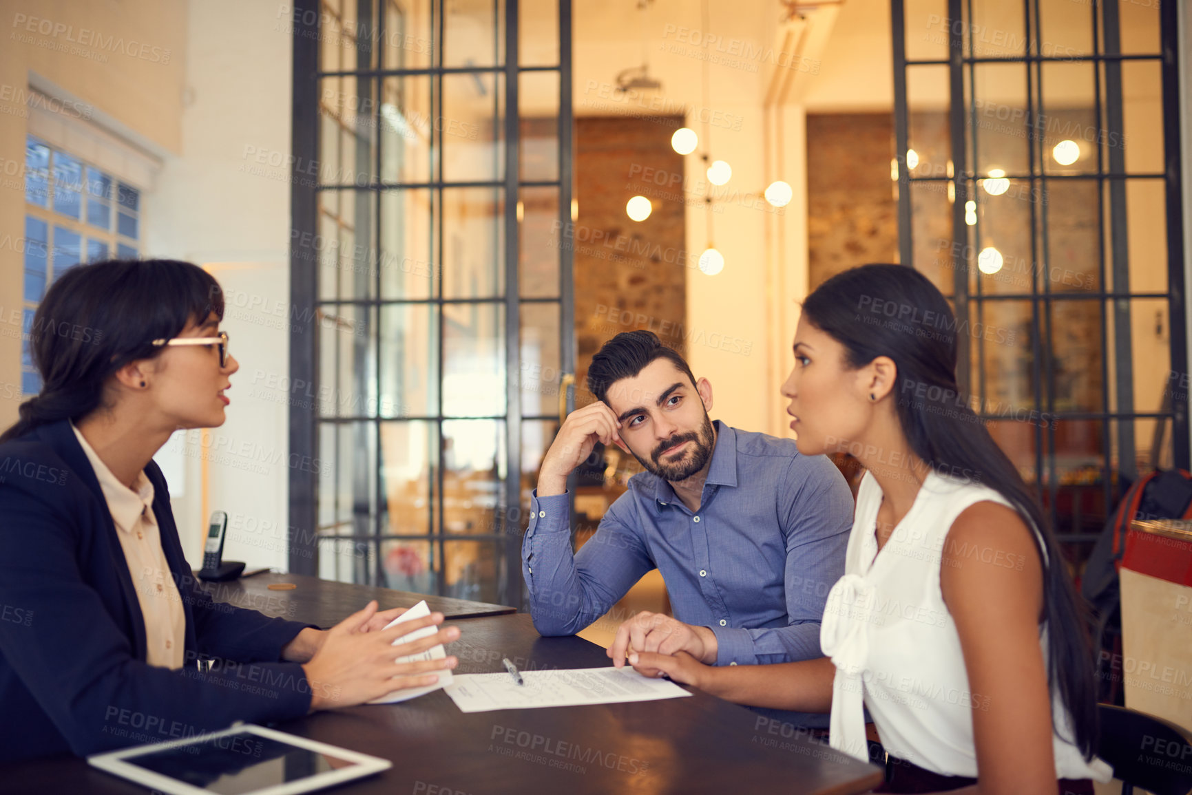 Buy stock photo Shot of a young couple meeting with a financial planner in an office