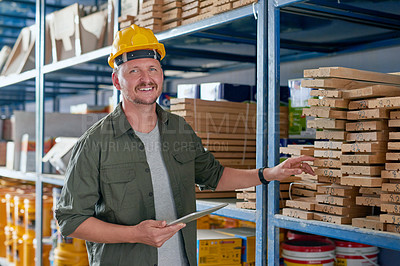 Buy stock photo Cropped portrait of a handsome mature construction worker using his tablet while standing in an industrial warehouse