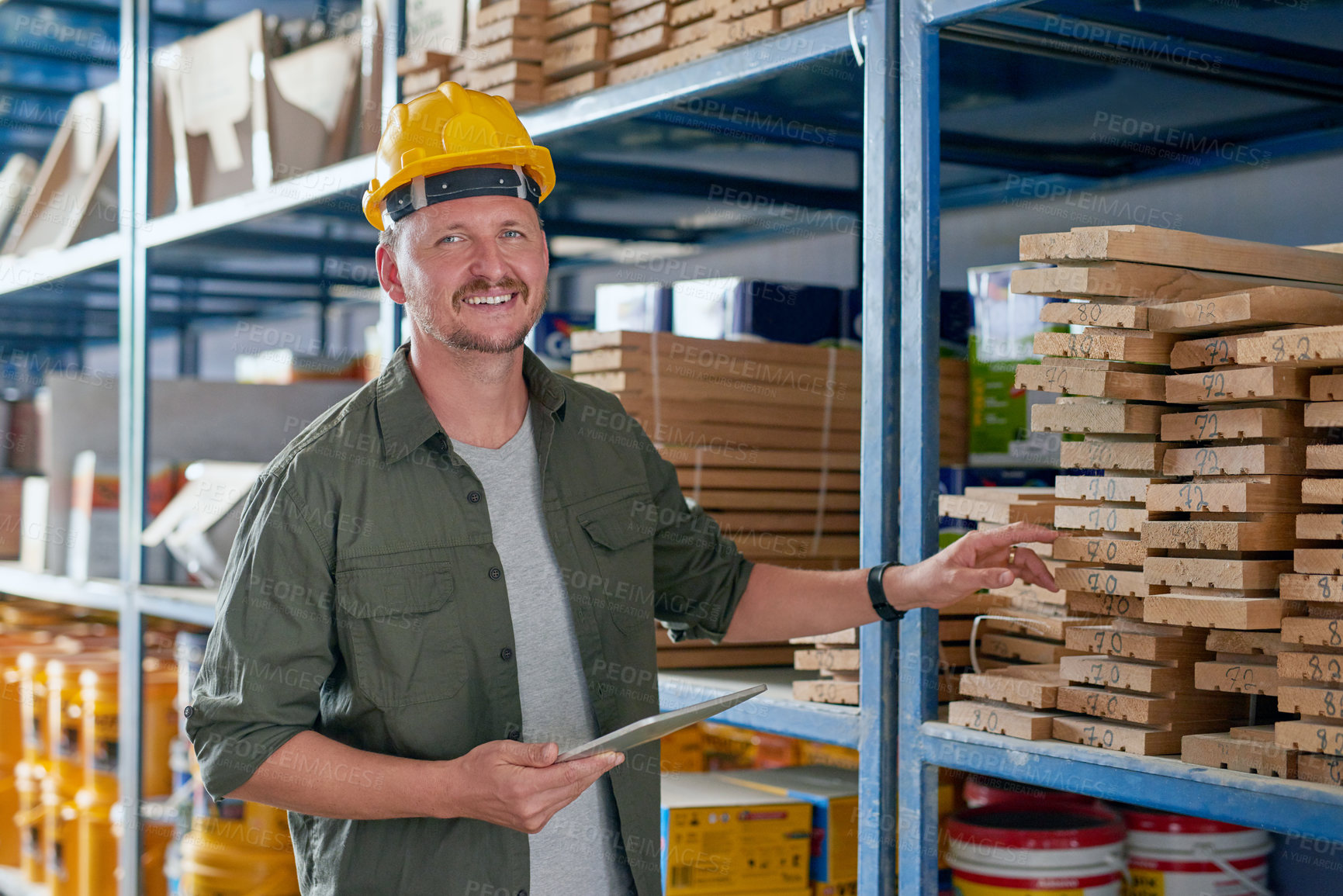 Buy stock photo Cropped portrait of a handsome mature construction worker using his tablet while standing in an industrial warehouse