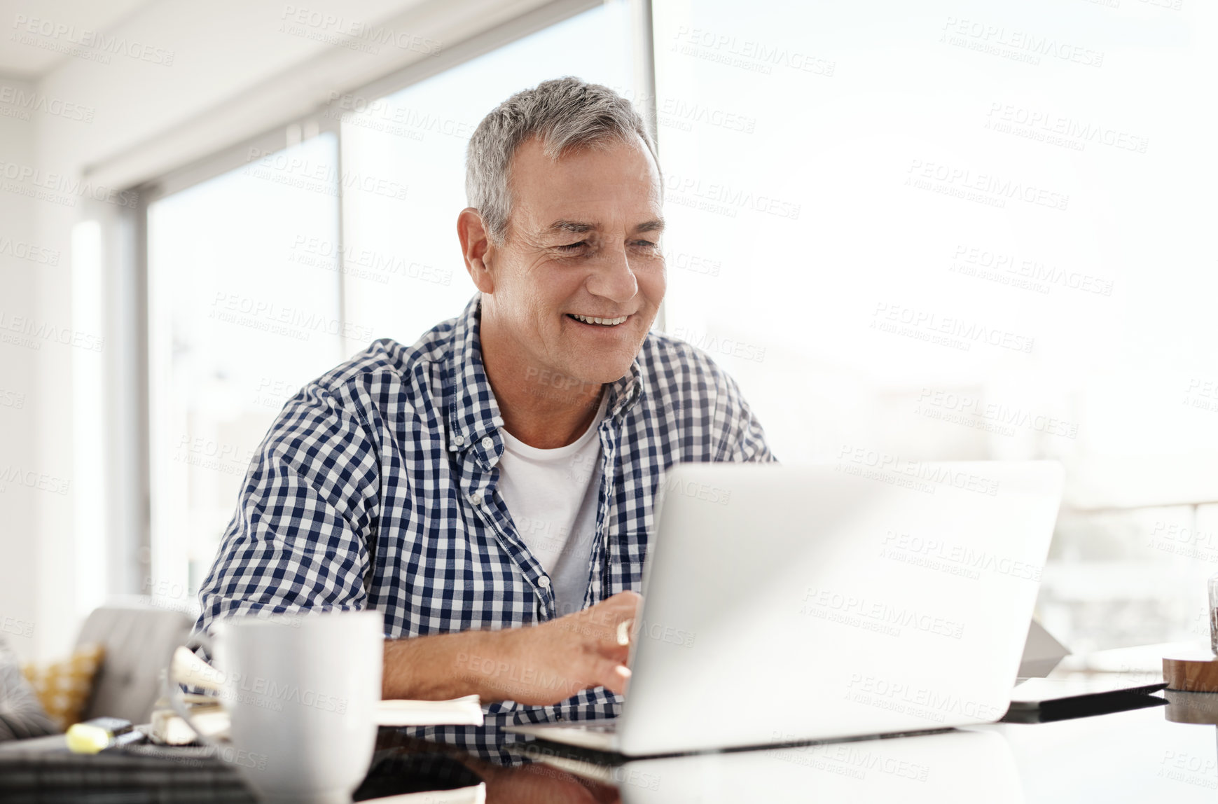 Buy stock photo Shot of a mature man working on a laptop at home