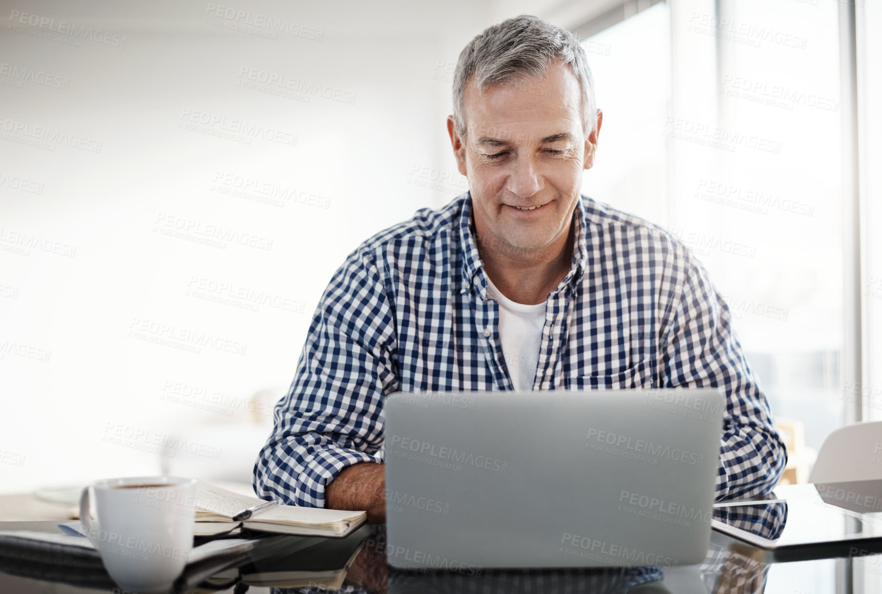 Buy stock photo Shot of a mature man working on a laptop at home