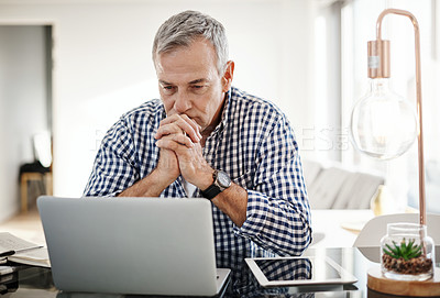 Buy stock photo Shot of a mature man looking anxious while working on a laptop at home