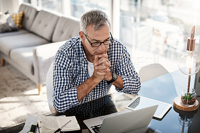 Buy stock photo High angle shot of a mature man working on a laptop at home