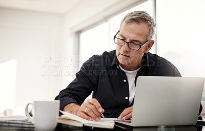 Buy stock photo Shot of a mature man going through some paperwork at home