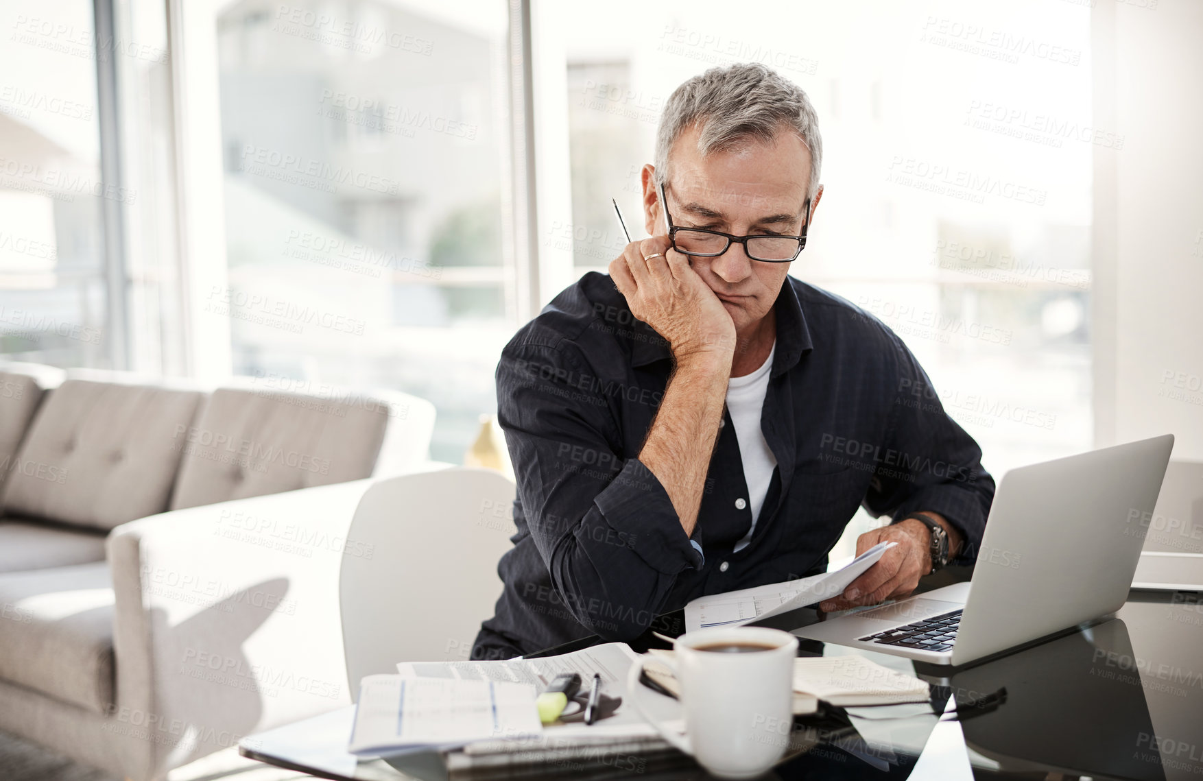 Buy stock photo Shot of a mature man going through some paperwork at home