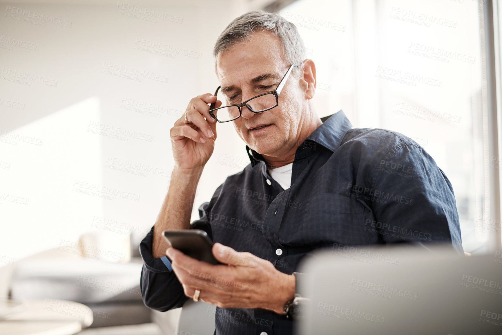 Buy stock photo Shot of a mature man using a cellphone at home
