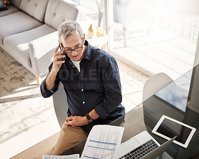 Buy stock photo High angle shot of a mature man talking on a cellphone at home