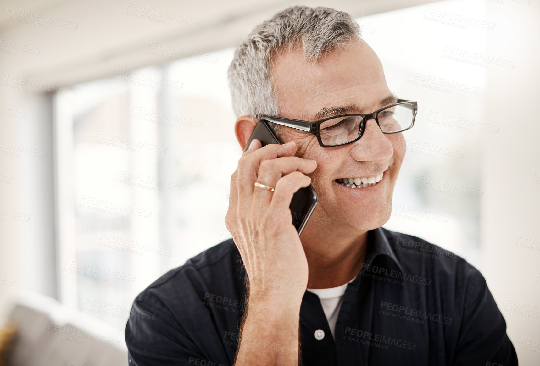 Buy stock photo Shot of a mature man talking on a cellphone at home