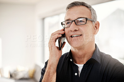 Buy stock photo Shot of a mature man talking on a cellphone at home
