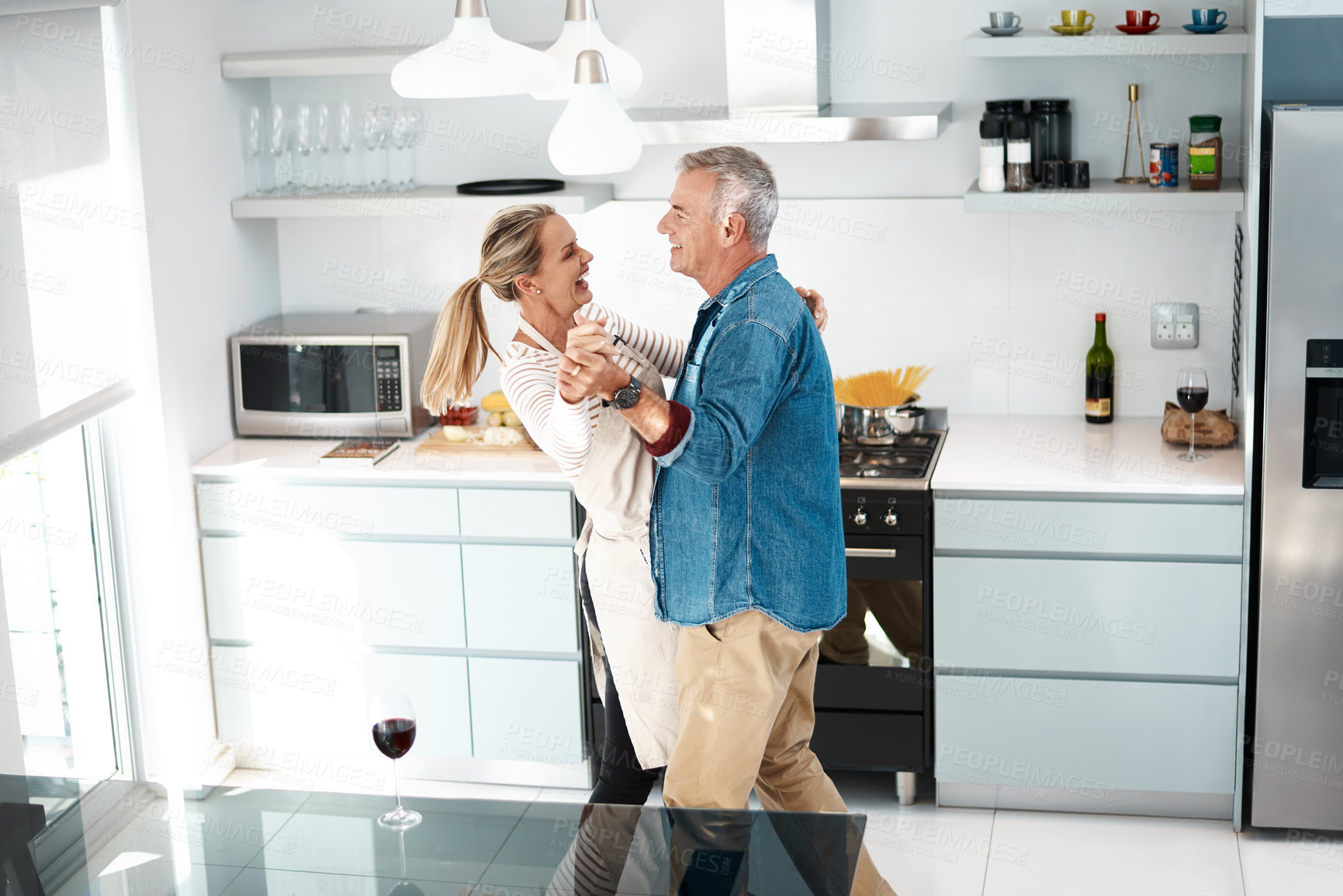Buy stock photo Cropped shot of a couple dancing in their kitchen