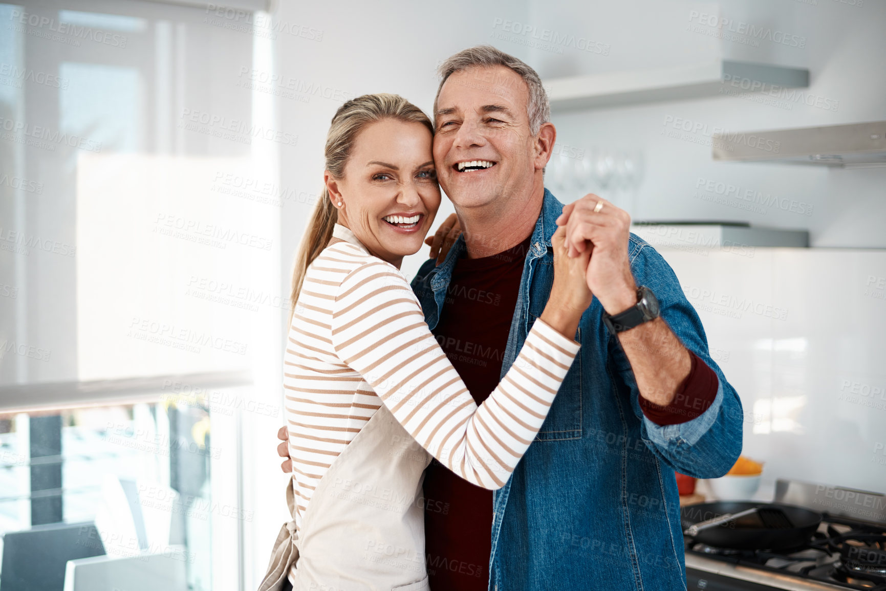 Buy stock photo Cropped shot of a couple dancing in their kitchen