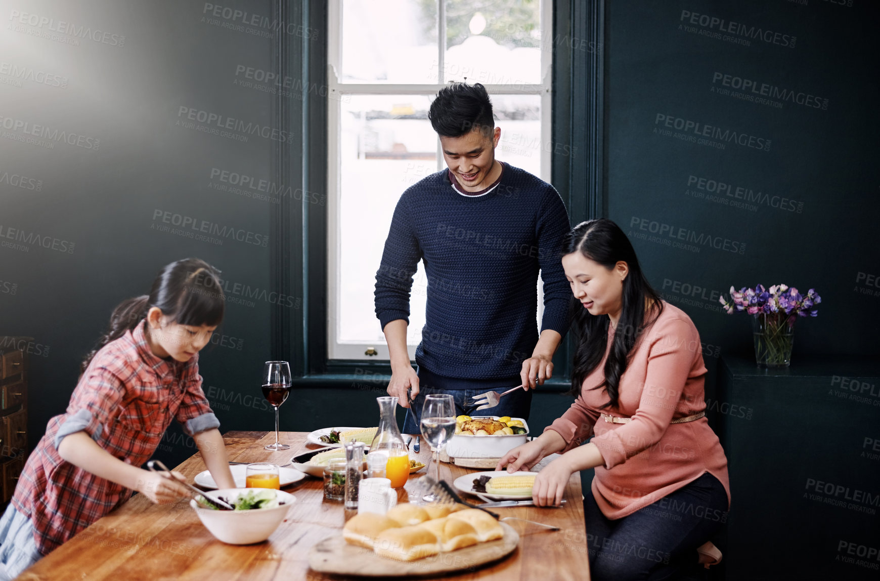 Buy stock photo Shot of a young family having a meal together at home