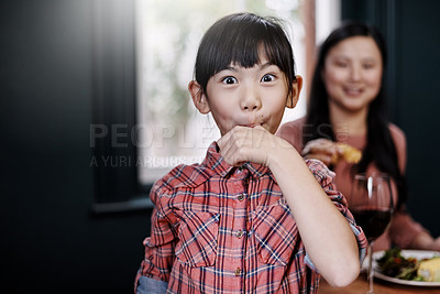 Buy stock photo Portrait of an adorable little girl licking her fingers while having a meal at home