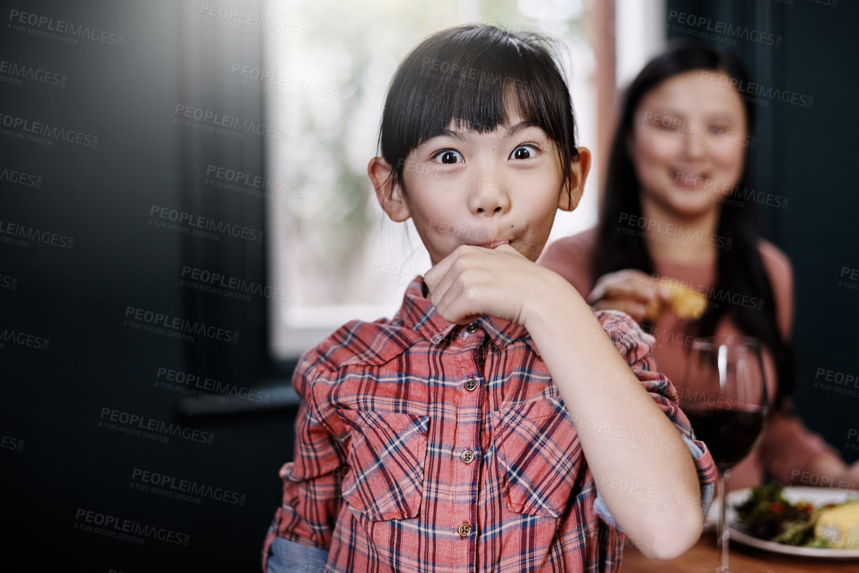 Buy stock photo Portrait of an adorable little girl licking her fingers while having a meal at home