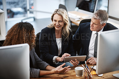 Buy stock photo Shot of a group of businesspeople working on a computer and digital tablet together in an office