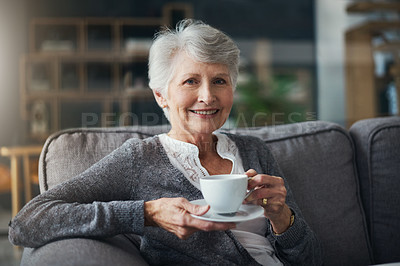 Buy stock photo Portrait of a senior woman enjoying a beverage while relaxing on the sofa at home
