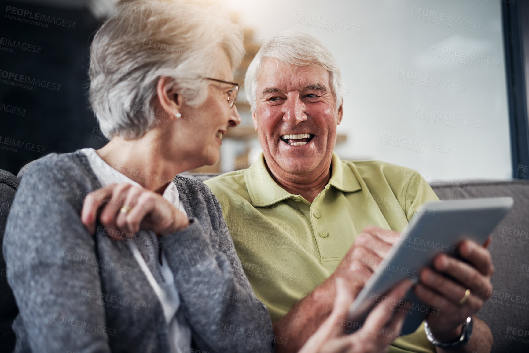 Buy stock photo Shot of a senior couple using a digital tablet together on the sofa at home