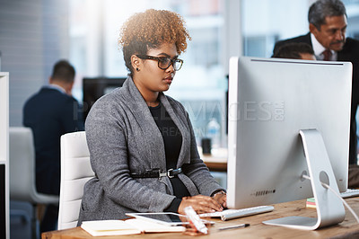 Buy stock photo Cropped shot of an attractive young businesswoman working at her desk in a modern office