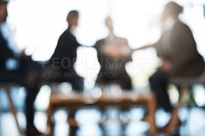 Buy stock photo Blurred shot of two unrecognizable businesspeople shaking hands during a meeting in the boardroom