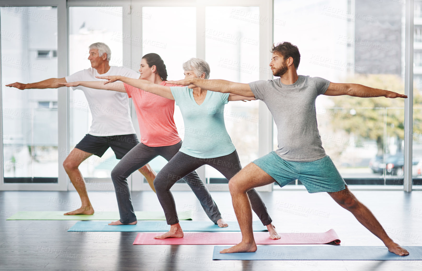 Buy stock photo Full length shot of a group of people practicing yoga