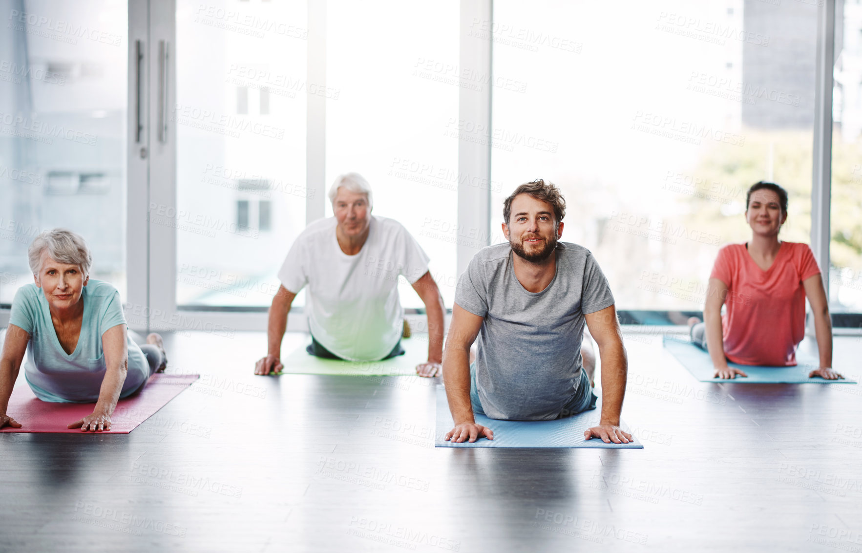 Buy stock photo Full length shot of a group of people practicing yoga