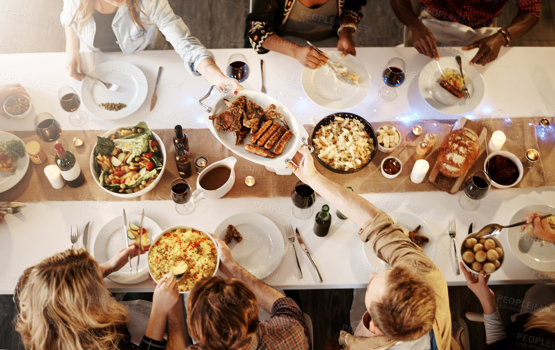 Buy stock photo High angle shot of friends getting together for a dinner party