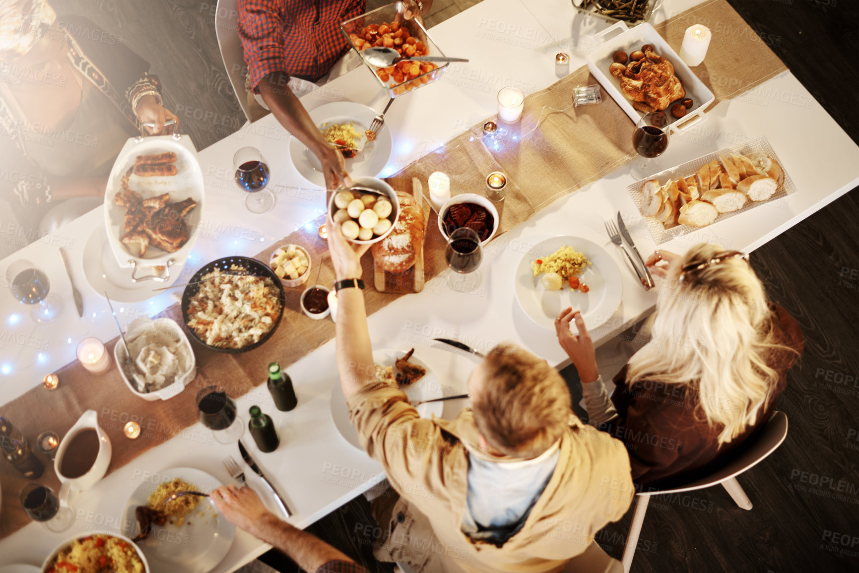 Buy stock photo High angle shot of friends getting together for a dinner party