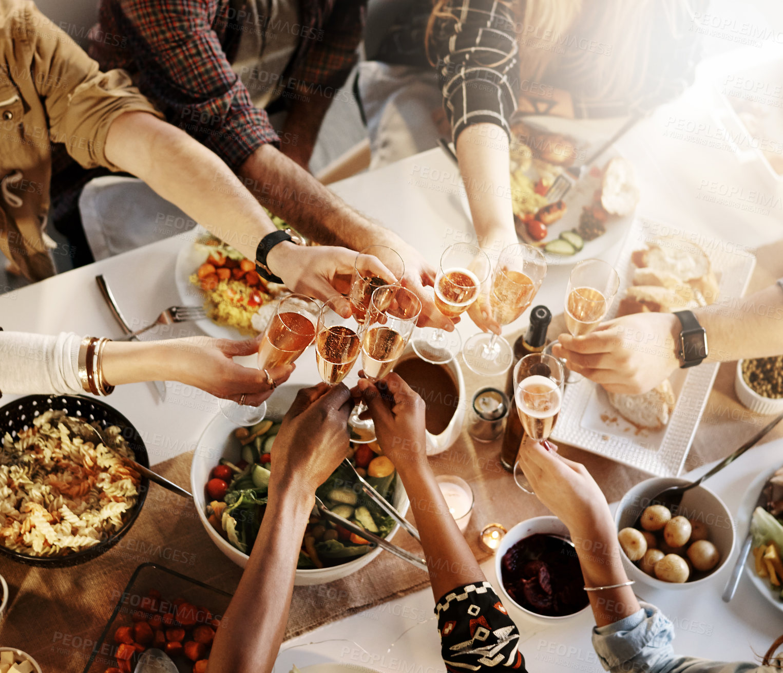 Buy stock photo Shot of a group of young friends making a toast at a dinner party