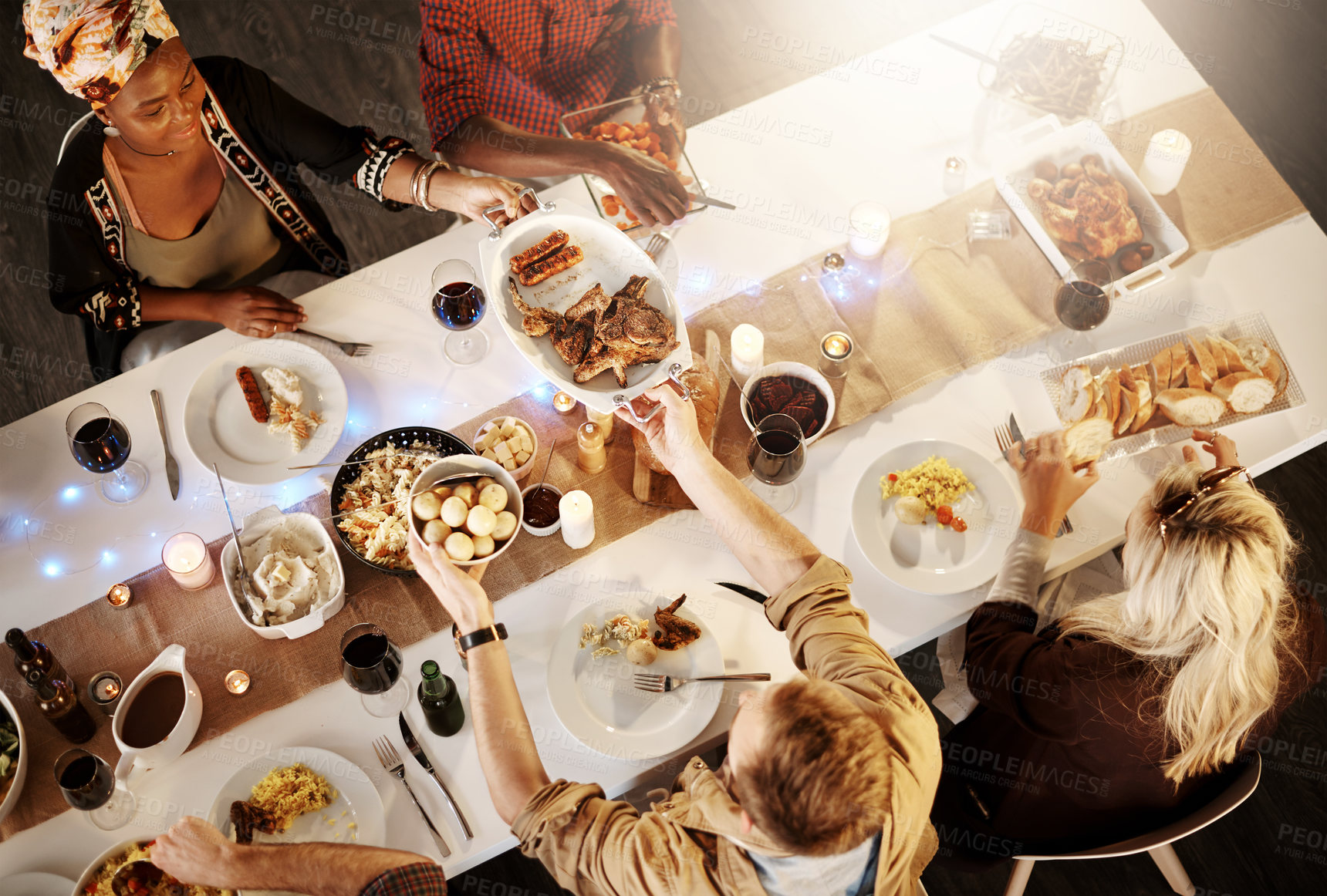 Buy stock photo High angle shot of friends getting together for a dinner party